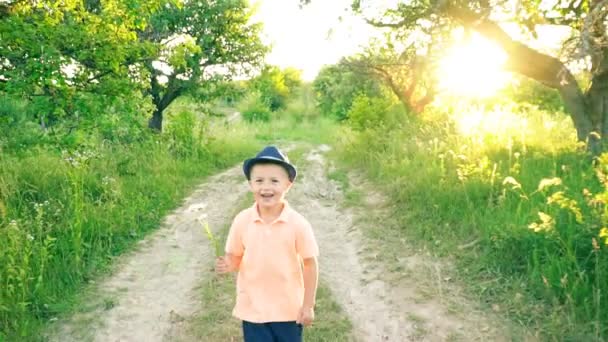 le petit garçon marche sur un chemin de terre 