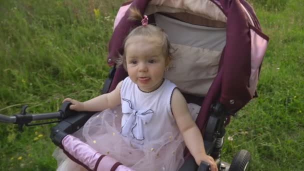 Маленькая девочка в коляске — стоковое видео