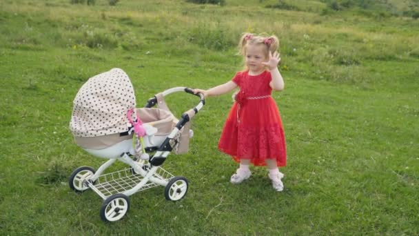 Liten flicka med en barnvagn — Stockvideo