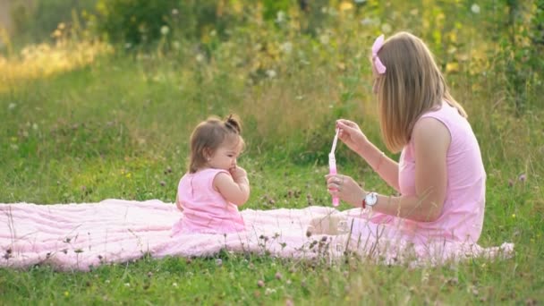 Anya és lánya ül a gyep — Stock videók