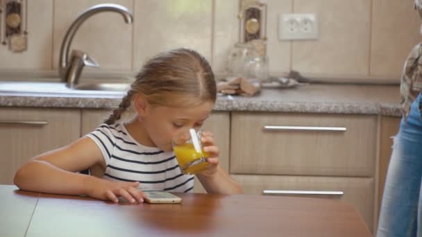 Kleines Mädchen trinkt Orangensaft — Stockvideo