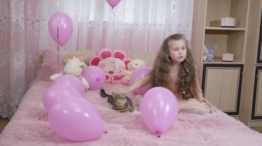 küçük kız bir kedi okşayarak