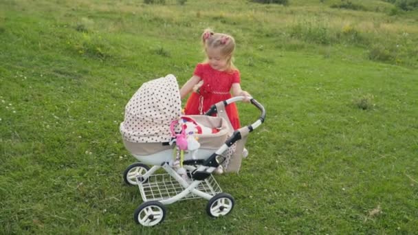 Liten flicka med en barnvagn — Stockvideo