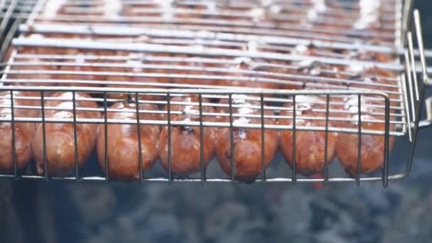 Варка колбасы на огне — стоковое видео