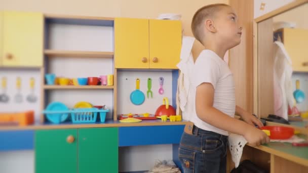 O menino está brincando o que está cozinhando — Vídeo de Stock