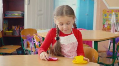 küçük kız yemek yemek bir oyuncak mutfak