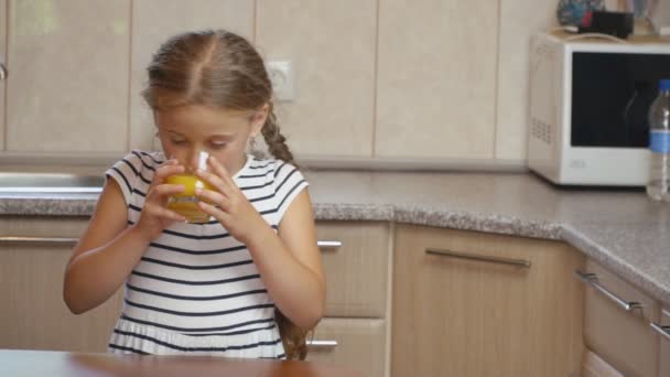 Lilla flickan dricker apelsinjuice — Stockvideo