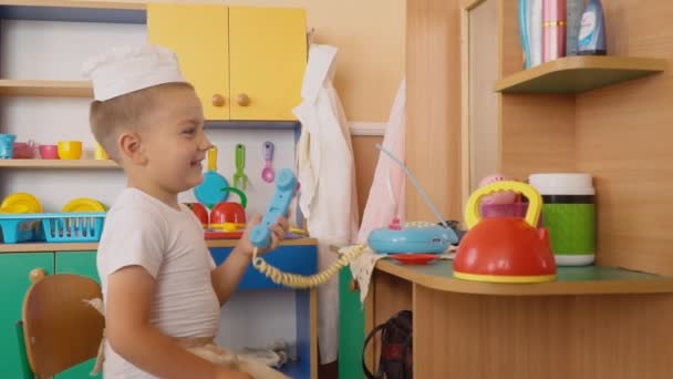 De kleine jongen speelt wat is koken — Stockvideo