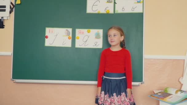 Девочка стоит у доски — стоковое видео