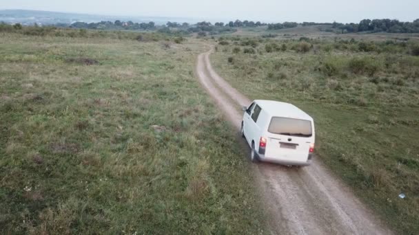 Un coche de color blanco monta en un camino de tierra — Vídeo de stock