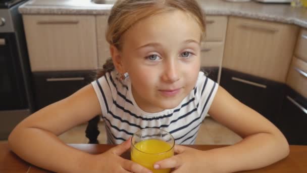 Little girl drinks orange juice — Stock Video