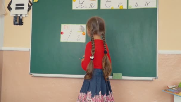 Дівчина стоїть біля дошки — стокове відео