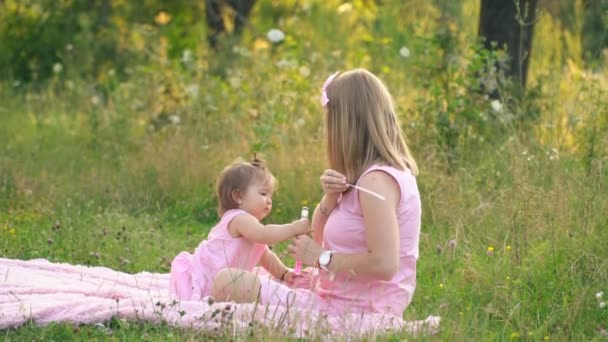 妈妈和女儿坐在草坪上。 — 图库视频影像