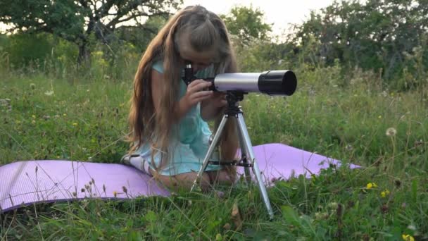 Little girl is looking through a telescope — Stock Video