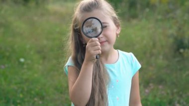 küçük kız bir büyüteç görünüyor
