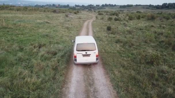 Un coche de color blanco monta en un camino de tierra — Vídeo de stock