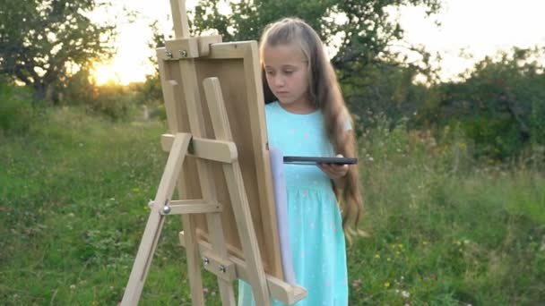 Küçük kız doğa üzerinde çizer — Stok video