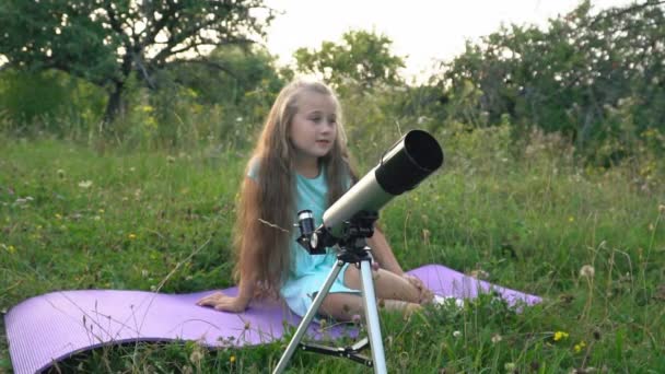 Μικρό Κορίτσι Ψάχνει Μέσα Από Ένα Τηλεσκόπιο Καθμένος Στη Φύση — Αρχείο Βίντεο