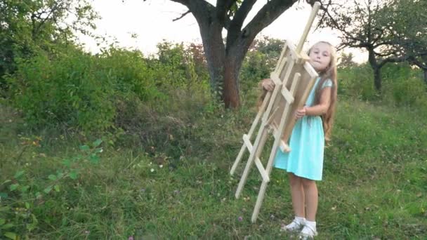 Flickan bär ett staffli för ritning — Stockvideo