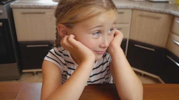 Mała dziewczynka siedzi przy stole — Wideo stockowe
