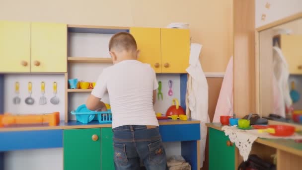 O menino está brincando o que está cozinhando — Vídeo de Stock