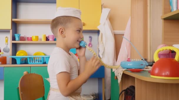 Der kleine Junge spielt, was kocht — Stockvideo