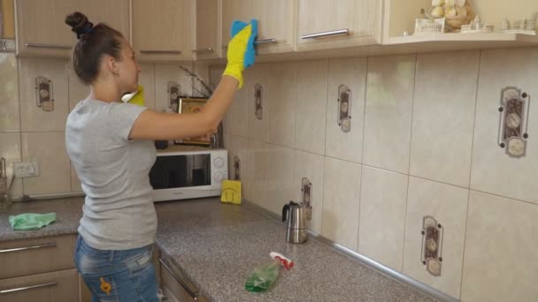 Женщина убирает на кухне — стоковое видео