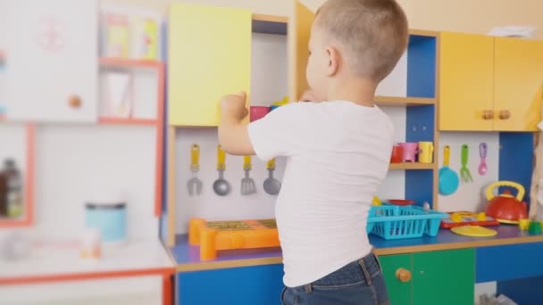 A kisfiú játszik, mi készül — Stock videók