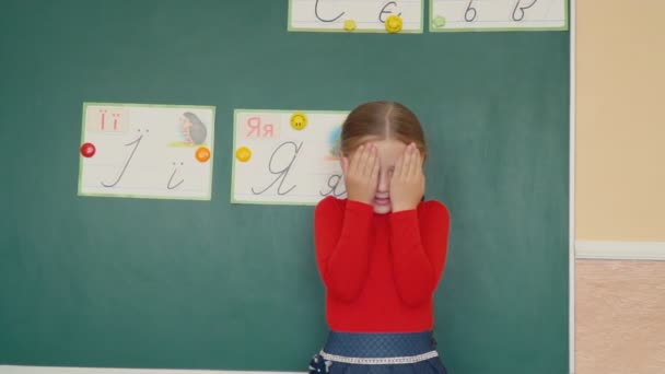 मुलगी ब्लॅकबोर्ड जवळ उभे आहे — स्टॉक व्हिडिओ