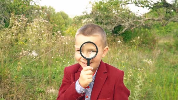 Un ragazzo con una lente d'ingrandimento — Video Stock