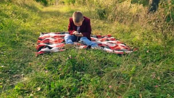 Niño jugando en el teléfono en los juegos — Vídeos de Stock