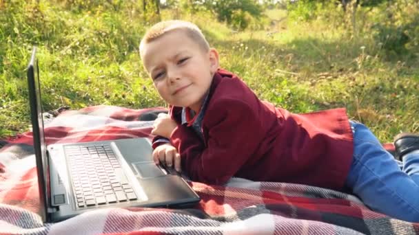 The boy is looking at the computer — Stock Video