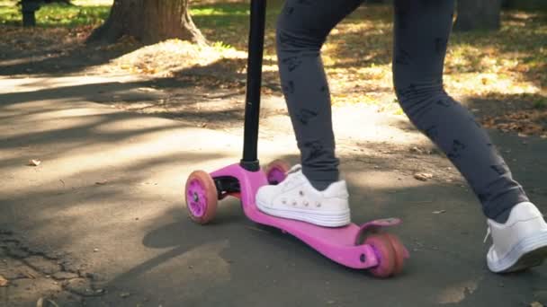 A menina está montando uma scooter — Vídeo de Stock