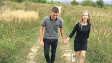 Toprak yolda yürüyen genç bir çift