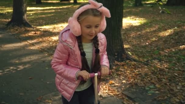 A menina está montando uma scooter — Vídeo de Stock