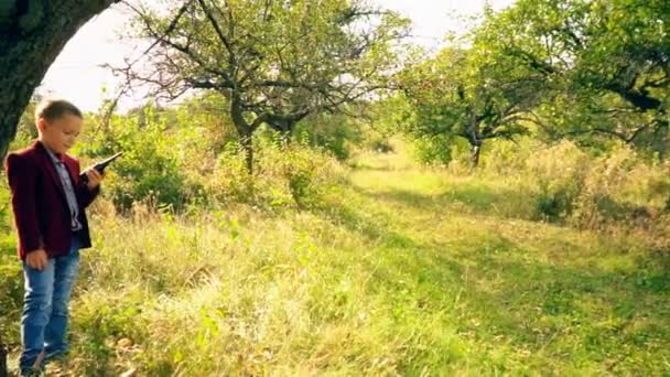 Jongen met een walkie-gesprek in de natuur — Stockvideo