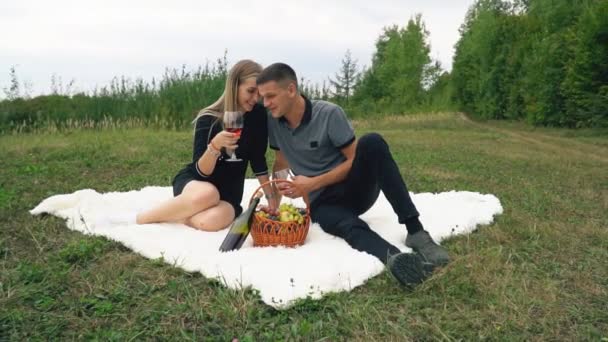 Ungt par sitter på gräsmattan — Stockvideo