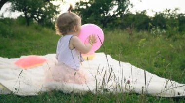 Küçük kız bir balonla oynuyor.