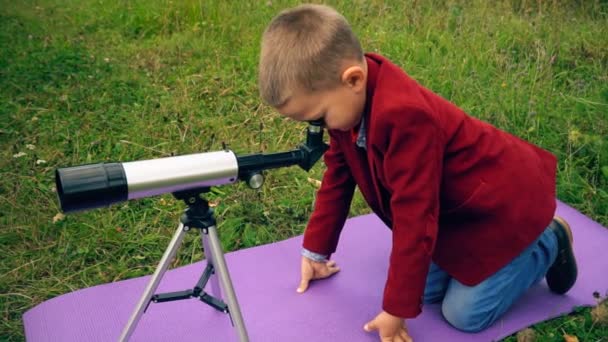 Jongen met een telescoop in de natuur — Stockvideo