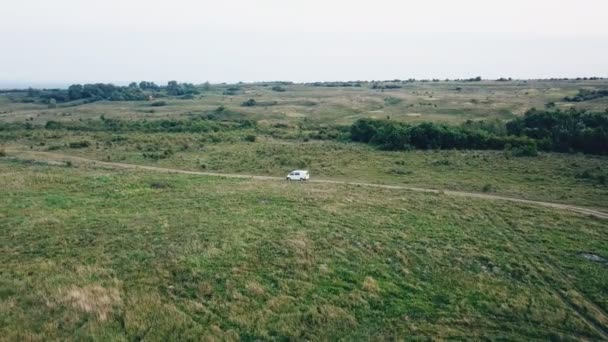 Ein Auto weißer Farbe fährt auf einem Feldweg — Stockvideo