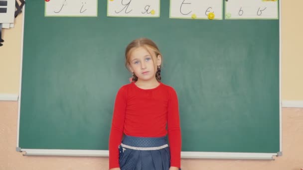 Το κορίτσι στέκεται κοντά σε μαυροπίνακα — Αρχείο Βίντεο