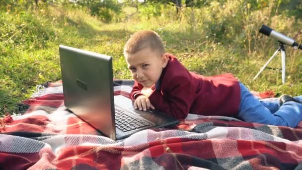 The boy is looking at the computer — Stock Video