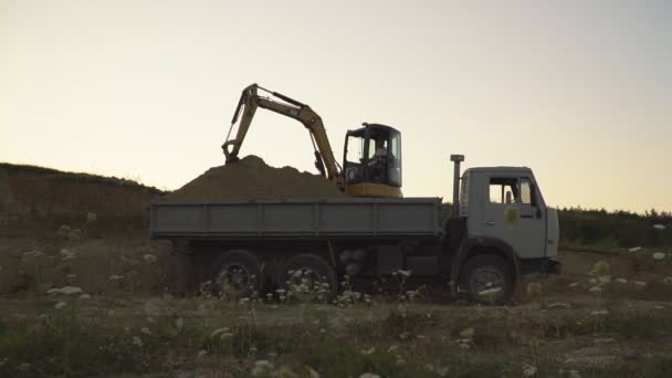 Grävmaskin laddar en lastbil — Stockvideo