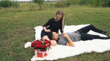 Çimenlikte oturan genç bir çift