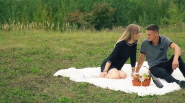 Çimenlikte oturan genç bir çift