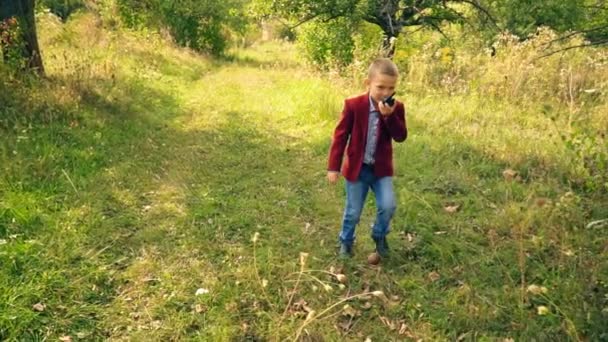 Мальчик с говорящим голосом на природе — стоковое видео
