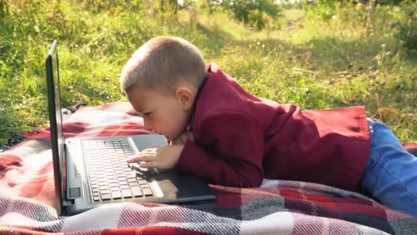 Der Junge schaut auf den Computer — Stockvideo