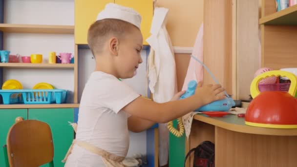 O menino está brincando o que está cozinhando — Vídeo de Stock