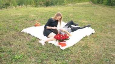 Çimenlikte oturan genç bir çift