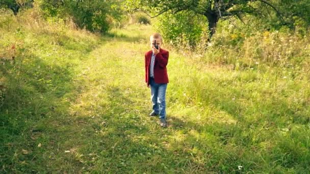 Chico con un walkie-talk en la naturaleza — Vídeo de stock